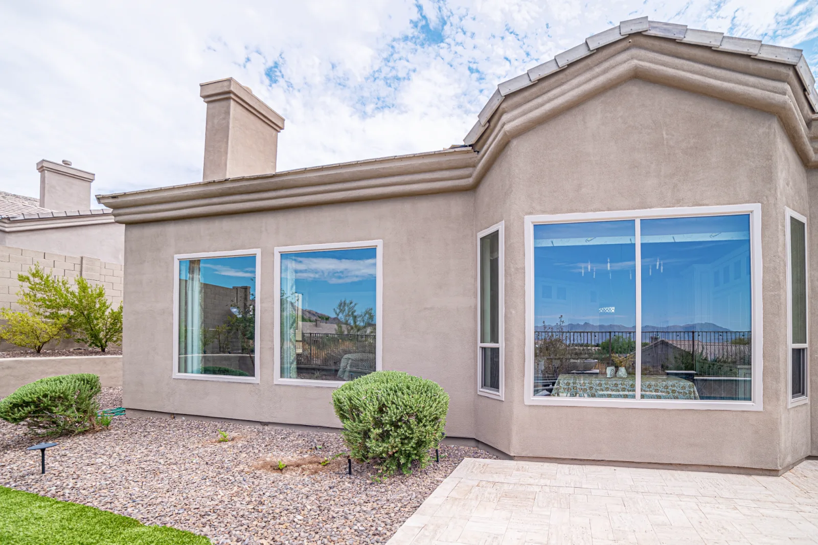 Two completed replacement windows on an Arizona stucco exterior
