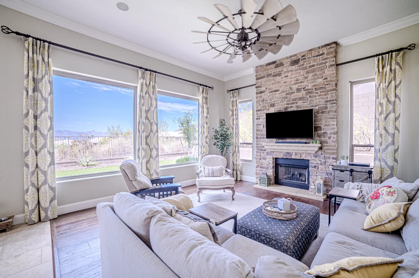 Finished living room with a large picture window beside a fireplace