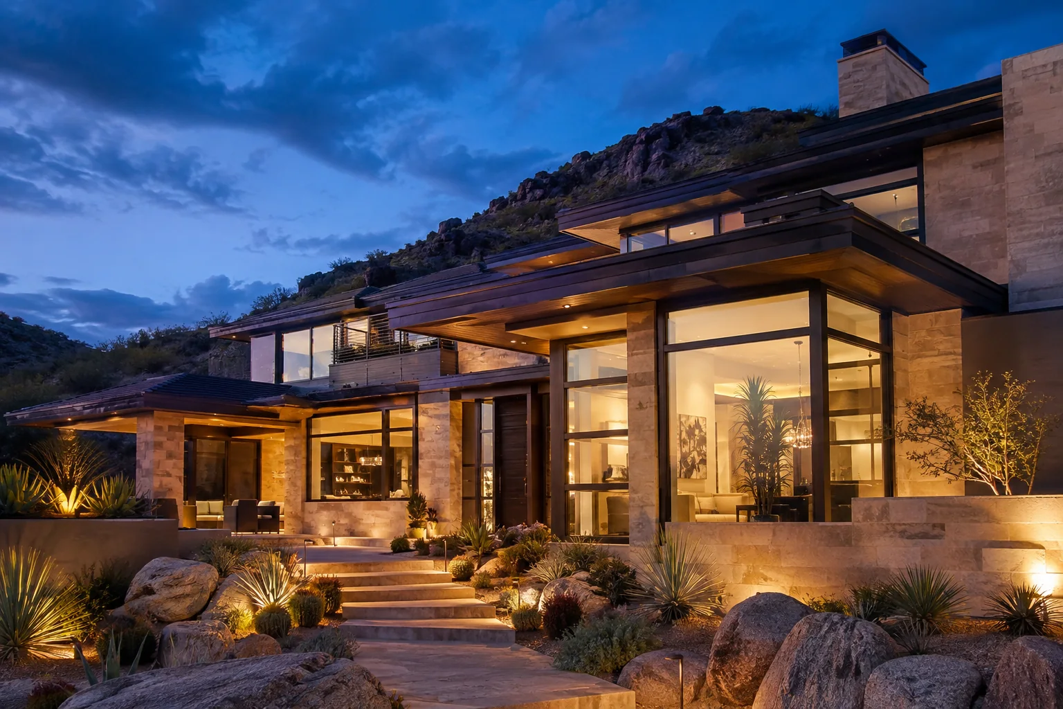 Contemporary Arizona home with expansive illuminated windows at dusk